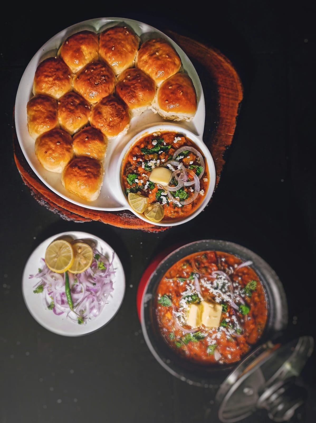 Platter of buttered pav with spiced curry bowl and onion salad garnish