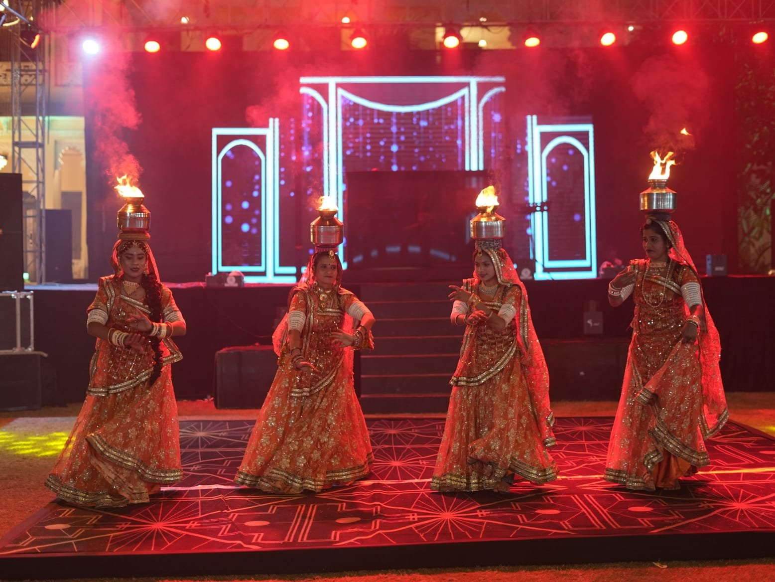 Rajasthani folk dancers performing with fire props on royal event stage