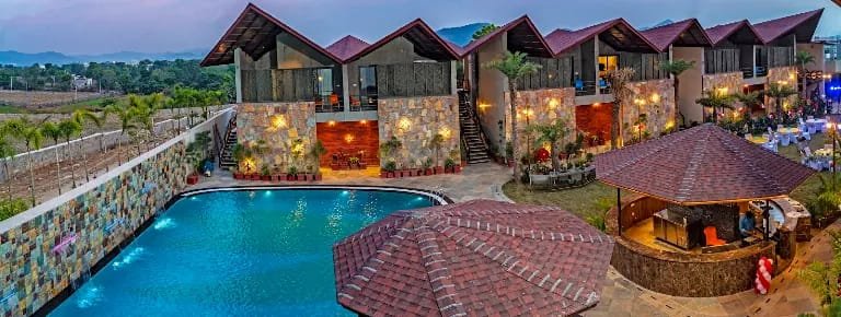 Panoramic exterior of hillside resort with outdoor swimming pool and mountain backdrop