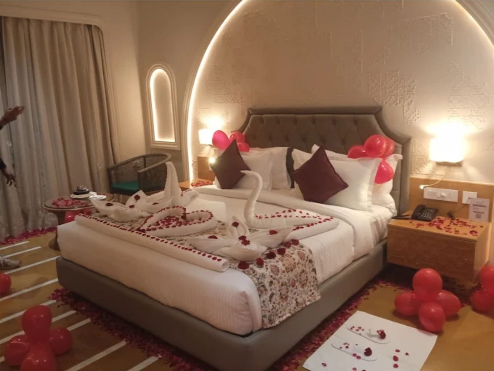 Luxury honeymoon bedroom suite with swan towel arrangement and rose petals at Weddings Mine property