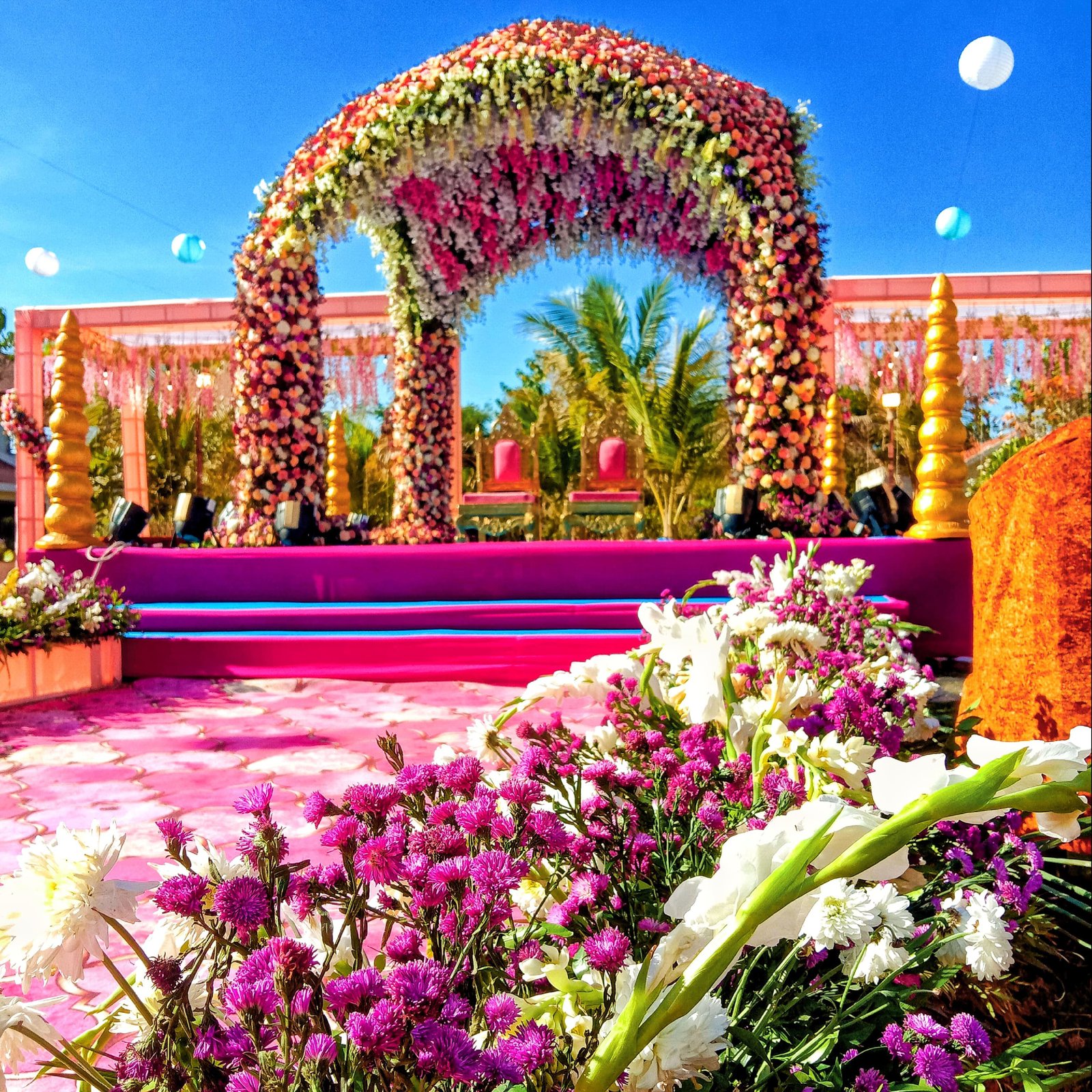 Outdoor wedding mandap with lavish floral archway and carpeted aisle in Udaipur