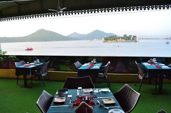 Jhumar Restaurant decorated lake-view dining table with glassware and floral centerpiece